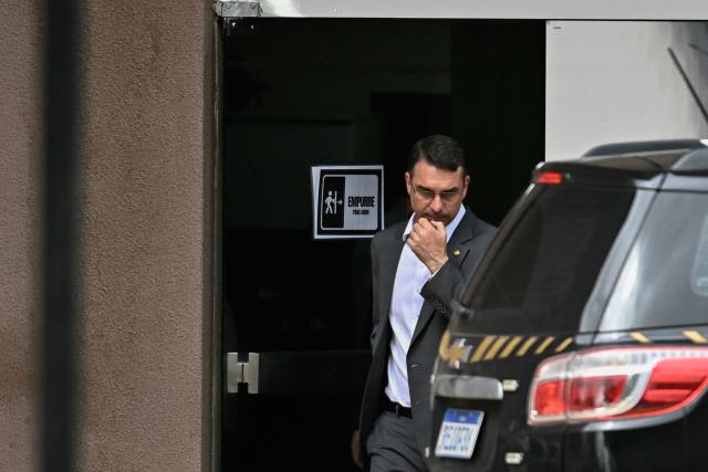 Senator Flavio Bolsonaro, son of former Brazilian president Jair Bolsonaro, leaves the Federal Police headquarters after visiting his father, in Brasilia, on December 09, 2025. (Photo by Ton MOLINA / AFP)