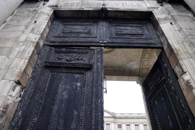 (FILES) The burnt door of Bordeaux's city hall, is pictured on March 24, 2023, the day after it was set on fire by demonstrators during a rally against pension reform, a week after the government pushed a pensions reform through parliament without a vote, using the article 49.3 of the constitution. The new door of Bordeaux's city hall is set to be inaugurated on December 12, 2025, in the presence of Mayor Pierre Humic following its thirty-month restoration. (Photo by ROMAIN PERROCHEAU / AFP)