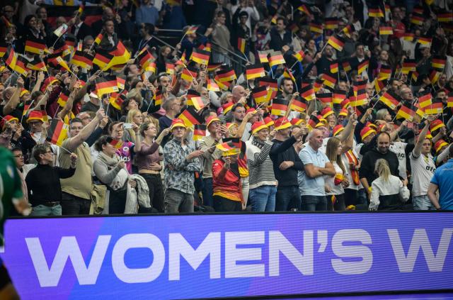Germany supporters wave flags prior to the quarter final match between Germany and Brazil of the IHF Women's Handball World Championship in Dortmund, western Germany, on December 9, 2025. (Photo by Sascha Schuermann / AFP)