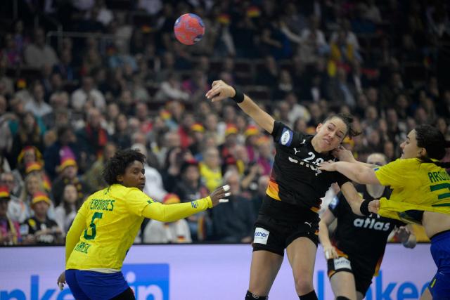 Germany's left back #20 Emily Vogel shoots the ball during the quarter final match between Germany and Brazil of the IHF Women's Handball World Championship in Dortmund, western Germany on December 9, 2025. (Photo by Sascha Schuermann / AFP)