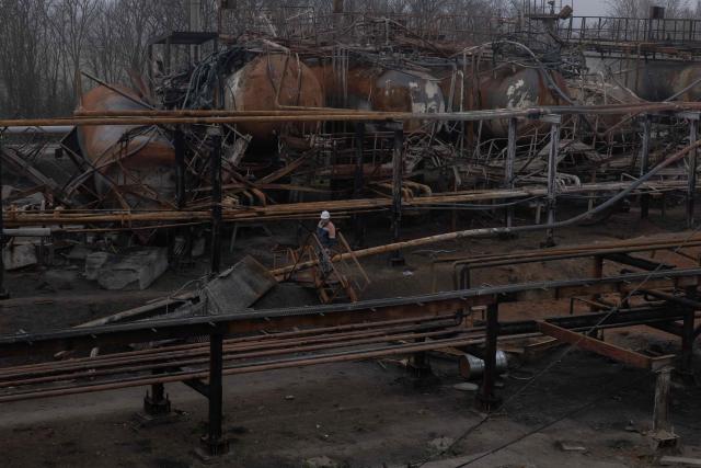 (FILES) An employee walks past damaged parts of the Naftogaz gas facility, following Russian missile and drone attacks, in Ukraine, on December 2, 2025, amid the Russian invasion of Ukraine. Ukraine faces possibly its toughest winter since Russia invaded, the head of the country's state-run gas operator told AFP in December 2025, accusing Moscow of being determined to cut off heating to civilians as temperatures plunge below zero. (Photo by Roman PILIPEY / AFP)