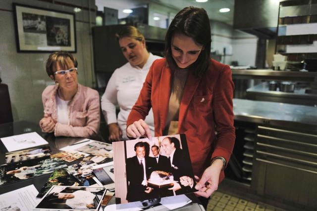 (FILES) Dominique Loiseau (L), wife of the late French chef Bernard Loiseau, and her daughters Berangere (R) and Blanche (C), look at family photographs in the kitchen of the restaurant "La Côte dOr - Le Relais Bernard Loiseau" in Saulieu, central France, on February 9, 2023. Dijon, Beaune, Besançon, Metz, and even Tokyo: despite the suicide of its eponymous owner, three-star chef Bernard Loiseau, in 2003, the establishment he founded 50 years ago has become a small empire. (Photo by Olivier CHASSIGNOLE / AFP)