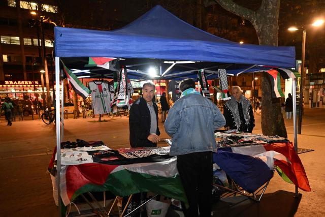 A vendor holds a stand with Palestinian flags ahead of a charity concert "Together for Palestine", at La Villette in Paris on December 9, 2025. (Photo by Anna KURTH / AFP)