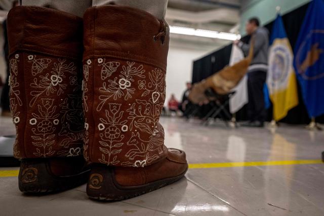 Details of shoes as Natan Obed, president of the Inuit Tapiriit Kanatami (ITK), speaks during for the unveiling of the indigenous artifacts at the Canadian Museum of History in Gatineau, Quebec, Canada, on December 9, 2025. The artifacts were returned to Montreal on Saturday December 6, 2025, after having been at the Vatican Museum for nearly a century. It took almost 20 years, including indigenous communities visiting the Vatican and meeting Pope Francis in 2022, to have the items returned. (Photo by ANDREJ IVANOV / AFP)