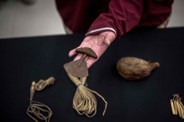 Darrel Nasogaluak, Elder and Chair of Tuktoyaktuk Community Corp., holds an ulu (a traditional inuit knife) during the unveiling of the indigenous artifacts at the Canadian Museum of History in Gatineau, Quebec, Canada, on December 09, 2025. The artifacts were returned to Montreal on Saturday December 6, 2025, after having been at the Vatican Museum for nearly a century. It took almost 20 years, including indigenous communities visiting the Vatican and meeting Pope Francis in 2022, to have the items returned. (Photo by ANDREJ IVANOV / AFP)