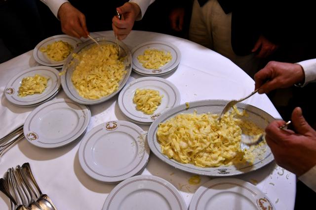 (FILES) Waiters serve fettuccine at the Il Vero Alfredo Restaurant in Rome on February 7, 2018 as it celebrates 110 years of its signature dish "fettuccine all'Alfredo". Italy is waiting for the final decision of Unesco, on December 10, 2025, regarding the recognition of Italian cuisine as an "Intangible Cultural Heritage of Humanity". (Photo by Alberto PIZZOLI / AFP)
