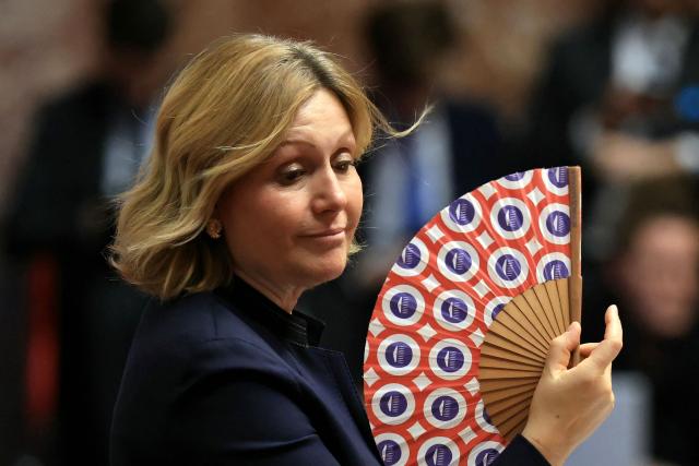 President of the French National Assembly Yael Braun-Pivet waves a National Assembly fan during the explanation of vote after the results of the vote on the third part of the Social Security financing bill for 2026 (PLFSS) at the National Assembly, France's lower house parliament, in Paris on December 9, 2025. (Photo by Alain JOCARD / AFP)