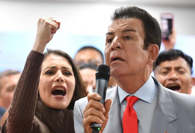 Salvador Nasralla, presidential candidate for the opposition Liberal Party, speaks during a press conference next to his wife Iroshka Elvir in Tegucigalpa on December 9, 2025. Nasralla made allegations of electoral corruption on December 9, 2025, after a stalled ballot count in the November 30 general election. (Photo by Orlando SIERRA / AFP)