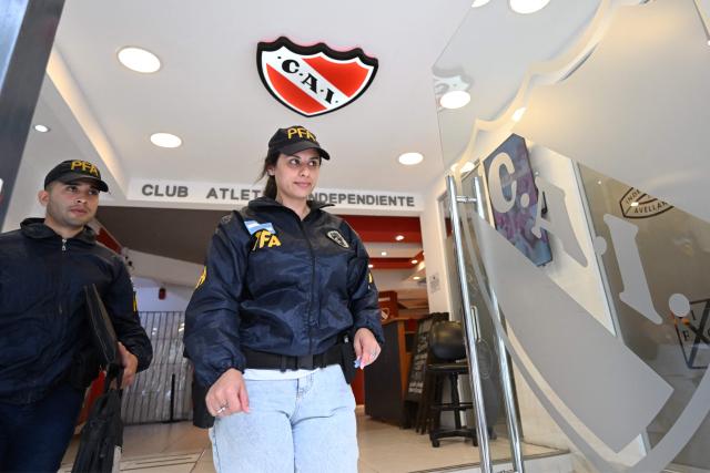 Federal Police officers leave the offices of the Club Atletico Independiente football team after a raid in Buenos Aires on December 9, 2025. Argentine authorities raided the headquarters of the national football association and several major teams on Tuesday as part of a money-laundering probe, a police source told AFP. (Photo by Luis ROBAYO / AFP)