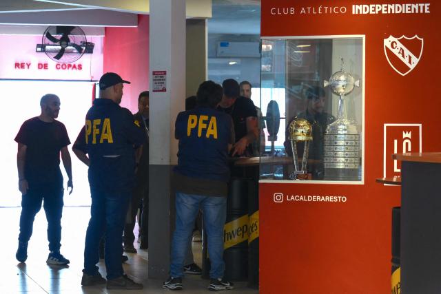 Federal Police officers leave the offices of the Club Atletico Independiente football team after a raid in Buenos Aires on December 9, 2025. Argentine authorities raided the headquarters of the national football association and several major teams on Tuesday as part of a money-laundering probe, a police source told AFP. (Photo by Luis ROBAYO / AFP)