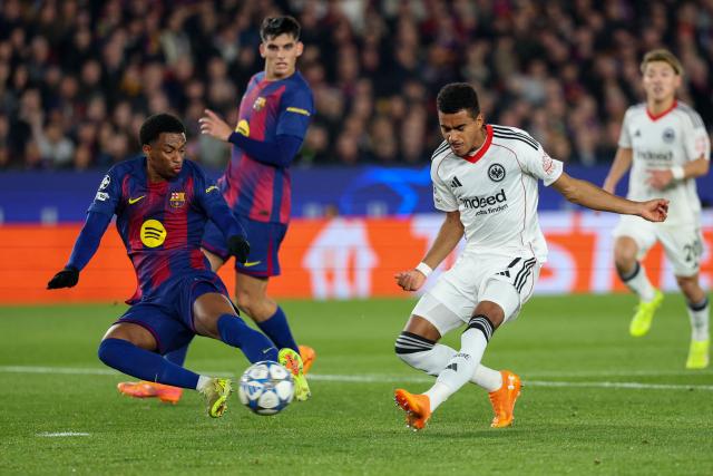 Frankfurt's German forward #07 Ansgar Knauff (R) scores his team's first goal past Barcelona's Spanish defender #03 Alex Balde during the UEFA Champions League league phase day 6 football match between FC Barcelona and Eintracht Frankfurt at Camp Nou Stadium in Barcelona on December 9, 2025. (Photo by Lluis GENE / AFP)