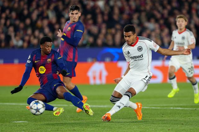 Frankfurt's German forward #07 Ansgar Knauff (R) scores his team's first goal past Barcelona's Spanish defender #03 Alex Balde during the UEFA Champions League league phase day 6 football match between FC Barcelona and Eintracht Frankfurt at Camp Nou Stadium in Barcelona on December 9, 2025. (Photo by Lluis GENE / AFP)