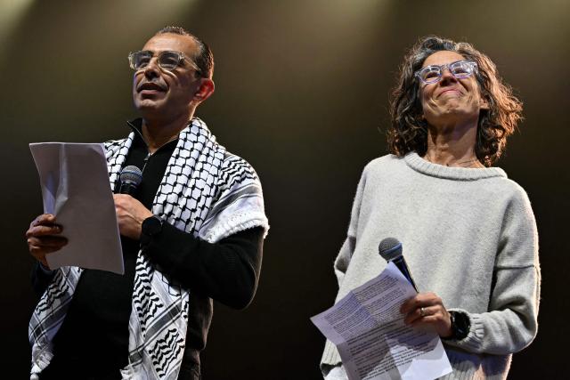 Deputy medical coordinator for Doctors Without Borders (MSF - Medecins Sans Frontieres) operations in Palestine Dr. Abu Abed Moughaisib (L) and Head of medical activities for Doctors Without Borders (MSF - Medecins Sans Frontieres) Karin Huster (R) speak on stage during a "Together for Palestine" benefit concert at the Zenith Paris event venue, in Paris on December 9, 2025. (Photo by Anna KURTH / AFP)