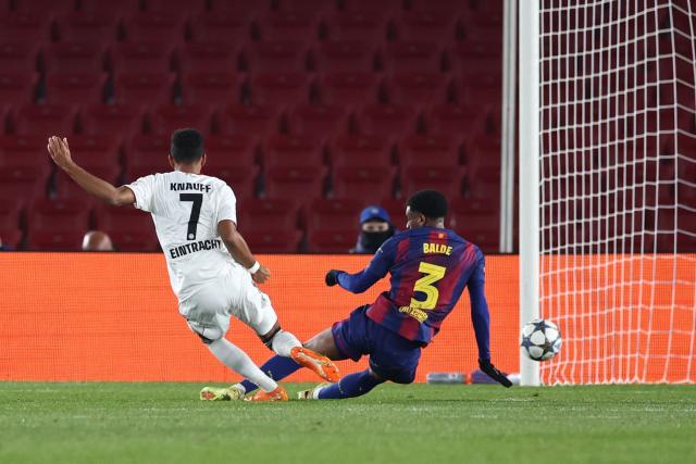 Frankfurt's German forward #07 Ansgar Knauff (L) scores his team's first goal past Barcelona's Spanish defender #03 Alex Balde during the UEFA Champions League league phase day 6 football match between FC Barcelona and Eintracht Frankfurt at Camp Nou Stadium in Barcelona on December 9, 2025. (Photo by Josep LAGO / AFP)