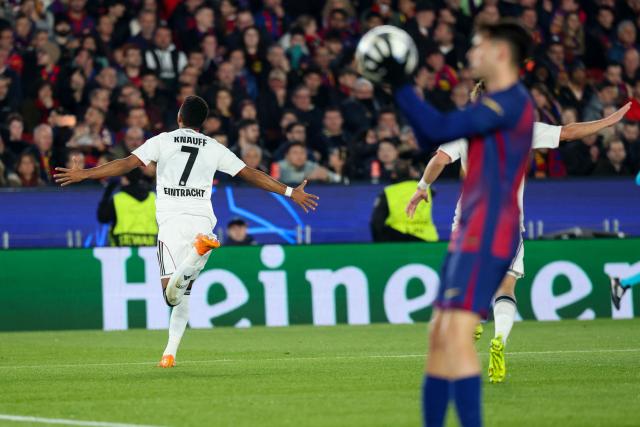 Frankfurt's German forward #07 Ansgar Knauff (L) celebrates scoring his team's first goal during the UEFA Champions League league phase day 6 football match between FC Barcelona and Eintracht Frankfurt at Camp Nou Stadium in Barcelona on December 9, 2025. (Photo by Lluis GENE / AFP)