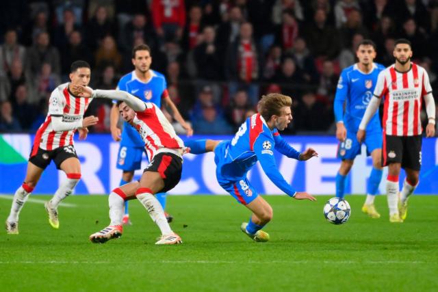 PSV Eindhoven's Dutch defender #02 Anass Salah-Eddine (centre L) and Atletico Madrid's Spanish midfielder #08 Pablo Barrios fall as they fight for the ball during the UEFA Champions League, league phase day 6, football match between PSV Eindhoven (NED) and Atletico Madrid (ESP), at the Philips Stadion, in Eindhoven, south of The Netherlands, on December 9, 2025. (Photo by JOHN THYS / AFP)