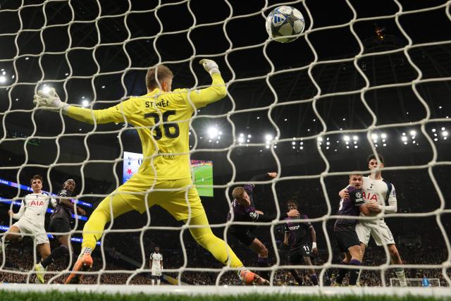 Slavia Prague's Czech defender #04 David Zima (C) heads the ball past Slavia Prague's Czech goalkeeper #36 Jindrich Stanek for an own-goal, Tottenham's first goal during the UEFA Champions League football league stage match between Tottenham Hotspur and Slavia Prague at the Tottenham Hotspur Stadium in London, on December 9, 2025. (Photo by Adrian DENNIS / AFP)