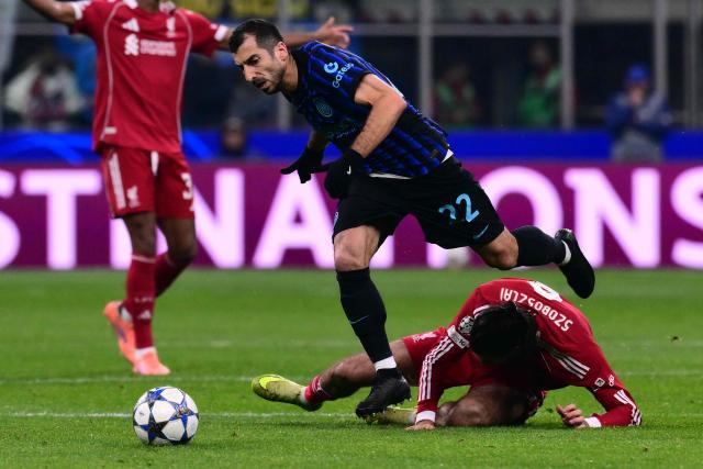 Liverpool's Hungarian midfielder #08 Dominik Szoboszlai fights for the ball with Inter Milan's Armenian forward #22 Henrikh Mkhitaryan during the UEFA Champions League phase day 6 football match between Inter Milan and Liverpool at San Siro stadium in Milan, on December 9, 2025. (Photo by Stefano RELLANDINI / AFP)