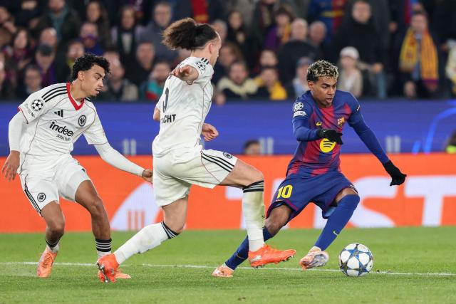 Barcelona's Spanish forward #10 Lamine Yamal (R) runs with the ball challenged by Frankfurt's Belgian defender #03 Arthur Theate (C) during the UEFA Champions League league phase day 6 football match between FC Barcelona and Eintracht Frankfurt at Camp Nou Stadium in Barcelona on December 9, 2025. (Photo by Lluis GENE / AFP)