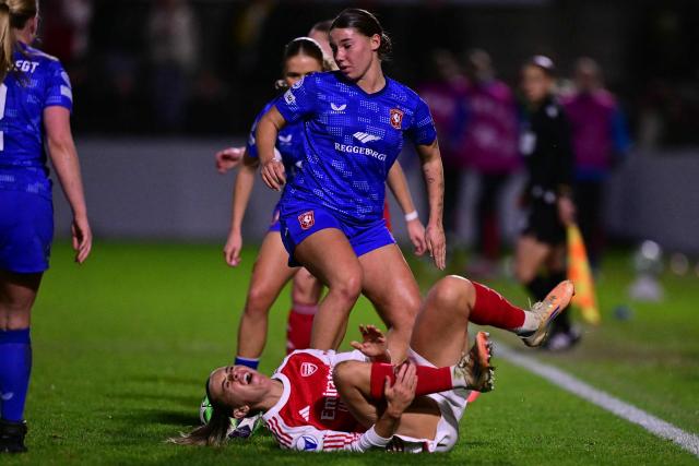 Arsenal's Irish striker #11 Katie McCabe reacts after a challenge by FC Twente's Dutch midfielder #06 Lynn Groenewegen (C) during the UEFA Women's Champions League, league phase football match between Arsenal and FC Twente at Meadow Park, in Borehamwood, north of London on December 9, 2025. (Photo by Ben STANSALL / AFP)