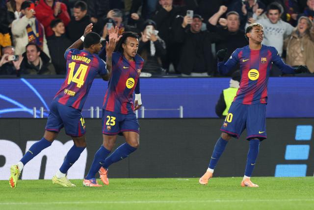 Barcelona's French defender #23 Jules Kounde (C) celebrates with Barcelona's English forward #14 Marcus Rashford after scoring his team's first goal during the UEFA Champions League league phase day 6 football match between FC Barcelona and Eintracht Frankfurt at Camp Nou Stadium in Barcelona on December 9, 2025. (Photo by Lluis GENE / AFP)