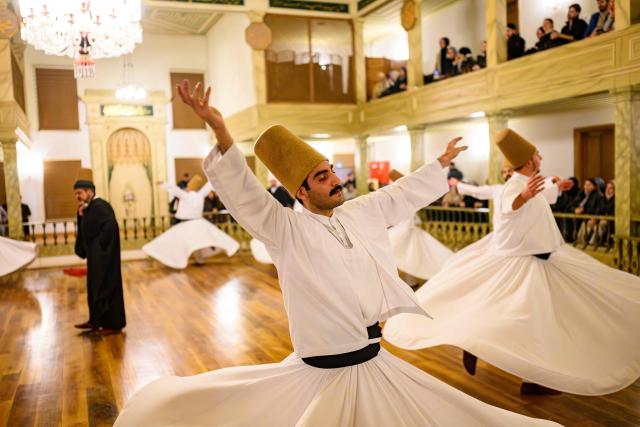 Whirling dervishes perform during a ceremony marking the anniversary of the death of Sufi mystic, poet and founder of sufism, Jelaleddin Mevlana Rumi at Yenikapi Mevlihanesi in Istanbul on December 9, 2025. The dervishes are adepts of Sufism, a mystical form of Islam that preaches tolerance and a search for understanding. Those who whirl, like planets around the sun, turn dance into a form of prayer. Some say the whirling dervishes belong more to the central, conservative city of Konya, where the father of Sufism, Mevlana Jalaluddin Rumi, lived in the 13th century, than to the cosmopolitan modern city. (Photo by Yasin AKGUL / AFP)