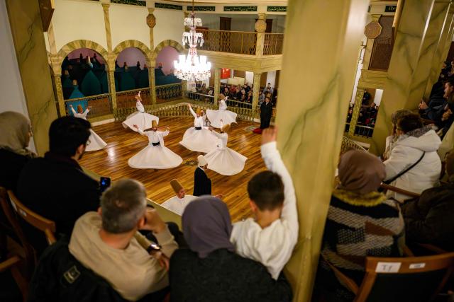 People watch as whirling dervishes perform during a ceremony marking the anniversary of the death of Sufi mystic, poet and founder of sufism, Jelaleddin Mevlana Rumi at Yenikapi Mevlihanesi in Istanbul on December 9, 2025. The dervishes are adepts of Sufism, a mystical form of Islam that preaches tolerance and a search for understanding. Those who whirl, like planets around the sun, turn dance into a form of prayer. Some say the whirling dervishes belong more to the central, conservative city of Konya, where the father of Sufism, Mevlana Jalaluddin Rumi, lived in the 13th century, than to the cosmopolitan modern city. (Photo by Yasin AKGUL / AFP)