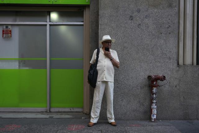 A man speaks on his phone in downtown Santiago on December 9, 2025. (Photo by Eitan ABRAMOVICH / AFP)