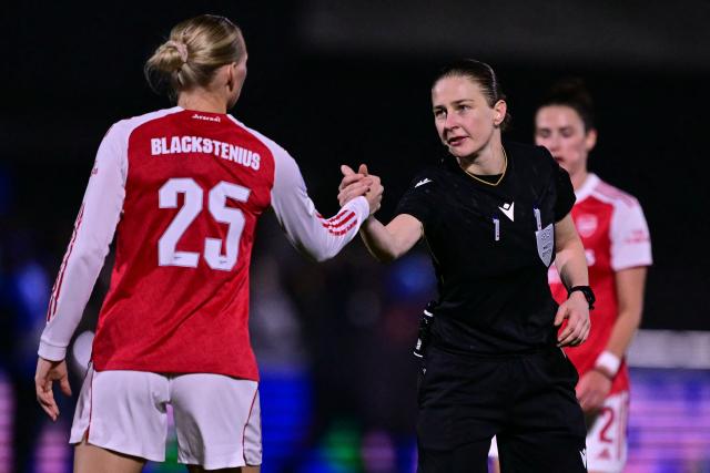 Polish referee Michalina Diakow (R) shakes hands with Arsenal's Swedish striker #25 Stina Blackstenius (L) on the pitch after the UEFA Women's Champions League, league phase football match between Arsenal and FC Twente at Meadow Park, in Borehamwood, north of London on December 9, 2025. Arsenal won the game 1-0. (Photo by Ben STANSALL / AFP)