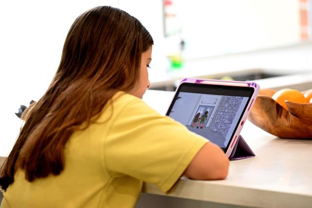 10-year-old Bianca Navarro watches a social media site at her home in western Sydney on December 10, 2025. Australia banned young teenagers from social media on Wednesday, launching a world-first crackdown designed to unglue children from addictive scrolling on the likes of Facebook, Instagram and TikTok. (Photo by Saeed KHAN / AFP)