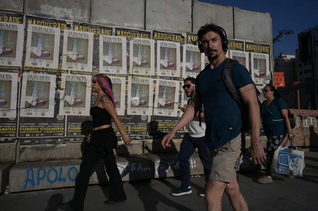 Pedestrians walk at Plaza Italia, a symbolic site of the 2019 social unrest known as Plaza de la Dignidad, which is undergoing renovations following the uprising, in Santiago on December 9, 2025. The second round of the Chilean presidential election on December 14, 2025, will pit two candidates who are totally opposed: Jeannette Jara, from a broad left-wing coalition with modest origins, and the far-right leader Jose Antonio Kast, an ultraconservative Catholic determined to massively expel undocumented migrants. (Photo by Eitan ABRAMOVICH / AFP)