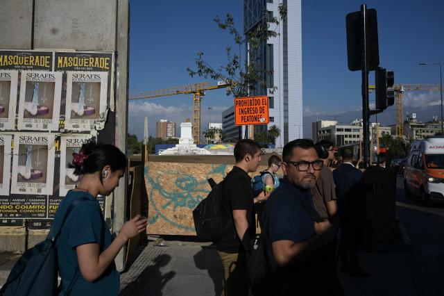 Pedestrians walk at Plaza Italia, a symbolic site of the 2019 social unrest known as Plaza de la Dignidad, which is undergoing renovations following the uprising, in Santiago on December 9, 2025. The second round of the Chilean presidential election on December 14, 2025, will pit two candidates who are totally opposed: Jeannette Jara, from a broad left-wing coalition with modest origins, and the far-right leader Jose Antonio Kast, an ultraconservative Catholic determined to massively expel undocumented migrants. (Photo by Eitan ABRAMOVICH / AFP)
