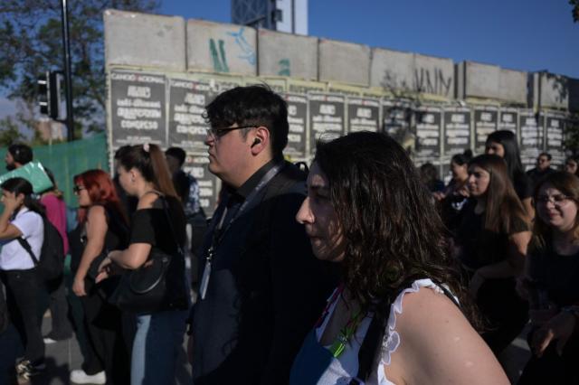 Pedestrians walk at Plaza Italia, a symbolic site of the 2019 social unrest known as Plaza de la Dignidad, which is undergoing renovations following the uprising, in Santiago on December 9, 2025. The second round of the Chilean presidential election on December 14, 2025, will pit two candidates who are totally opposed: Jeannette Jara, from a broad left-wing coalition with modest origins, and the far-right leader Jose Antonio Kast, an ultraconservative Catholic determined to massively expel undocumented migrants. (Photo by Eitan ABRAMOVICH / AFP)