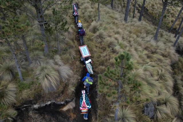 This aerial view shows people carrying images of the Virgin of Guadalupe during the pilgrimage to the Basilica of Guadalupe through Paso de Cortes, near Amecameca, Mexico on December 9, 2025. (Photo by Alfredo ESTRELLA / AFP)