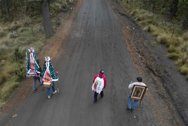 This aerial view shows people carrying images of the Virgin of Guadalupe during the pilgrimage to the Basilica of Guadalupe through Paso de Cortes, near Amecameca, Mexico on December 9, 2025. (Photo by Alfredo ESTRELLA / AFP)