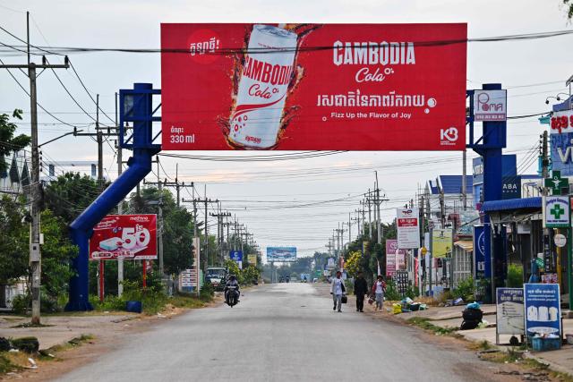 People walk along a street in Oddar Meanchey province on December 10, 2025 following clashes along the Cambodia-Thailand border. Fighting between Thailand and Cambodia spread to more parts of their contested border on Tuesday, forcing a mass exodus of civilians as the renewed hostilities derailed a US-brokered truce. (Photo by TANG CHHIN Sothy / AFP)