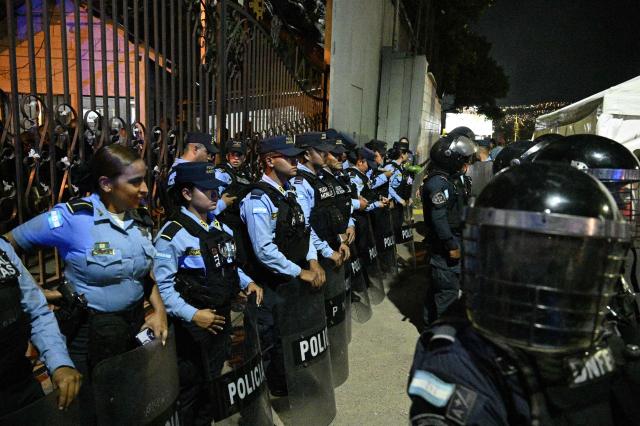 Police officers stand guard at the Professional Formation National Institute headquarters, where the electoral material for last presidential election is being held, in Tegucigalpa on December 9, 2025. Honduras' President Xiomara Castro on December 9, 2025, denounced what she called tampering with results in the Honduran general election, and accused US President Donald Trump of interfering in the vote. (Photo by Orlando SIERRA / AFP)