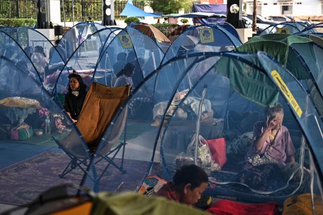 Displaced residents rest as they take shelter at an evacuee center during clashes along the Thai-Cambodia border in Thailand's Sa Kaeo Province on December 10, 2025. Fighting between Thailand and Cambodia spread to more parts of their contested border on December 9, forcing a mass exodus of civilians as the renewed hostilities derailed a US-brokered truce. (Photo by Lillian SUWANRUMPHA / AFP)