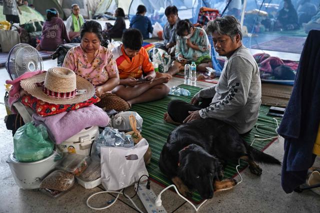 Displaced residents rest as they take shelter at an evacuee center during clashes along the Thai-Cambodia border in Thailand's Sa Kaeo Province on December 10, 2025. Fighting between Thailand and Cambodia spread to more parts of their contested border on December 9, forcing a mass exodus of civilians as the renewed hostilities derailed a US-brokered truce. (Photo by Lillian SUWANRUMPHA / AFP)