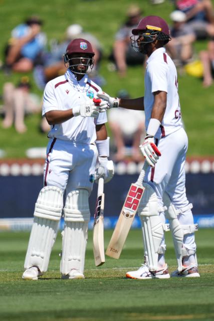 West Indies Shai Hope (L) bumps gloves with teammate West Indies Roston Chase during day one of the 2nd international Test cricket match between New Zealand and West Indies at the Basin reserve in Wellington on December 10, 2025. (Photo by Marty MELVILLE / AFP)