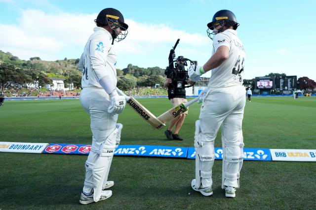 New Zealand's Devon Conway (L) and teammate Tom Latham prepare to walk onto the field at the start of their innings during day one of the 2nd international Test cricket match between New Zealand and West Indies at the Basin reserve in Wellington on December 10, 2025. (Photo by Marty MELVILLE / AFP)