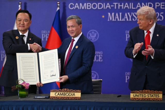 (FILES) US President Donald Trump (R) looks on as Cambodia's Prime Minister Hun Manet (C) and Thailand's Prime Minister Anutin Charnvirakul hold up signed documents during a ceremonial signing of a ceasefire agreement on the sidelines of the 47th Association of Southeast Asian Nations (ASEAN) Summit in Kuala Lumpur on October 26, 2025. Half a million evacuees in Cambodia and Thailand were sheltering in pagodas, schools and other safe havens on December 10, 2025 after fleeing renewed fighting in a century-old border dispute in which US President Donald Trump has vowed to again intercede. (Photo by ANDREW CABALLERO-REYNOLDS / AFP)