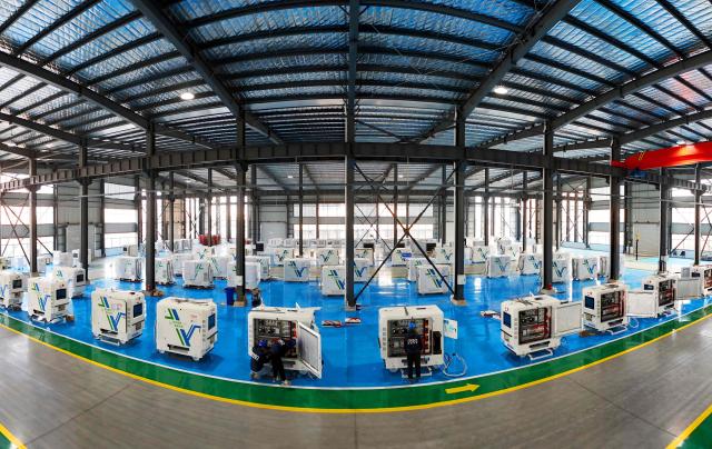 Workers install smart charging robots for mobile energy storage at a factory in Lianyungang, eastern China's Jiangsu province on December 10, 2025. (Photo by AFP) / China OUT