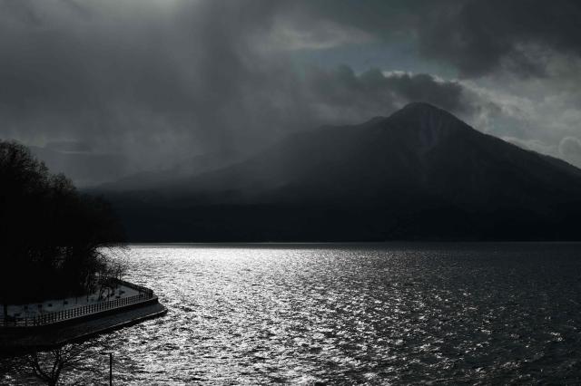 Mount Fuppushi is seen behind Lake Shikotsu in the Shikotsu Toya National Park in Japan’s northern Hokkaido prefecture on December 10, 2025. (Photo by GREG BAKER / AFP)