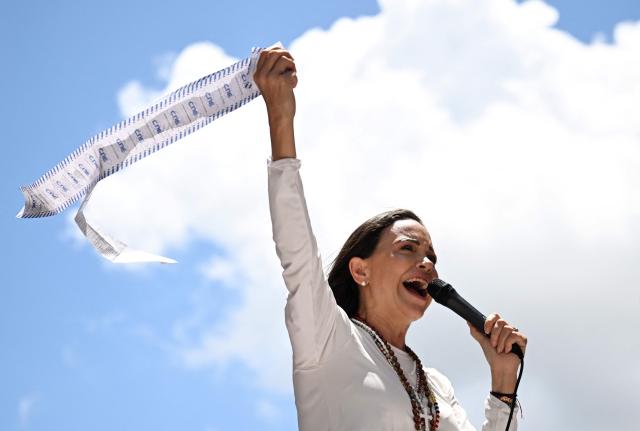 (FILES) Venezuelan opposition leader Maria Corina Machado speaks to supporters while holding up electoral records during a rally in Caracas on August 28, 2024. The director of the Nobel institute said on December 10, 2025, he was not aware where Venezuelan opposition leader Maria Corina Machado was after it was announced she would not attend the award of her Nobel Peace Prize. (Photo by JUAN BARRETO / AFP)