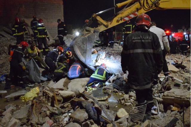 Emergency personnel search for victims in the rubble of two collapsed buildings in the Al Massira area of Fes late on December 9, 2025. Two four-storey buildings collapsed in the Moroccan city of Fes, killing at least 19 people, the state news agency said on December 10. (Photo by Ahmed ALAOUI MRANI / AFP)