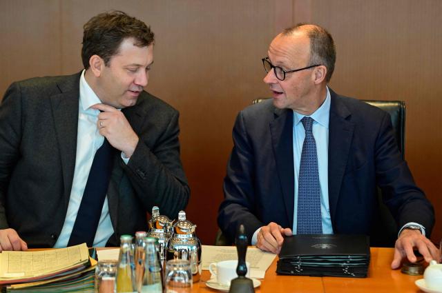 German Chancellor Friedrich Merz (R) and German Finance Minister and Vice Chancellor Lars Klingbeil sit at their places prior to the start of the weekly meeting of the German cabinet on December 10, 2025 at the Chancellery in Berlin. (Photo by John MACDOUGALL / AFP)