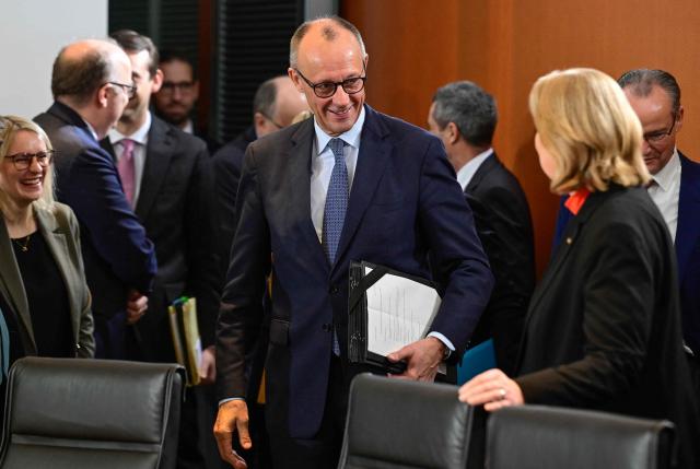 CORRECTION / German Chancellor Friedrich Merz (C) greets his cabinet colleagues as he arrives prior to the start of the weekly meeting of the German cabinet on December 10, 2025 at the Chancellery in Berlin. (Photo by John MACDOUGALL / AFP) / “The erroneous mention[s] appearing in the metadata of this photo by John MACDOUGALL has been modified in AFP systems in the following manner: [German Chancellor Friedrich Merz] instead of [German Finance Minister and Vice Chancellor Lars Klingbeil ]. Please immediately remove the erroneous mention[s] from all your online services and delete it (them) from your servers. If you have been authorized by AFP to distribute it (them) to third parties, please ensure that the same actions are carried out by them. Failure to promptly comply with these instructions will entail liability on your part for any continued or post notification usage. Therefore we thank you very much for all your attention and prompt action. We are sorry for the inconvenience this notification may cause and remain at your disposal for any further information you may require.”