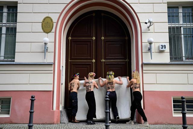 Topless members of the feminist activist group FEMEN use mattresses as banners during an action in support of jailed Moroccan activist Ibtissame "Betty" Lachgar on international Human Rights Day 2025, on December 10, 2025 in front of Morocco's embassy to Germany in Berlin. The 50-year-old clinical psychologist and feminist activist Ibtissame Lachgar was arrested in August 2025 after sparking an uproar for posting online a picture of herself wearing a T-shirt with the word "Allah" in Arabic followed by "is lesbian". A Moroccan court sentenced Lachgar to 30 months behind bars for "offending Islam". (Photo by John MACDOUGALL / AFP)