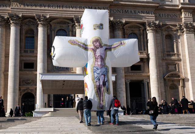Pope Leo XIV (C) receives an inflatable crucifix offered by the Italian island Ventotene at the end of the weekly general audience in the Vatican on December 10, 2025. (Photo by TIZIANA FABI / AFP)